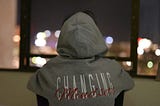 Someone staring at a night sky trough his room, need an inspiration. His hoodie screen-printed text says ‘Changing Mindset’.