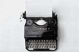 an overhead view of an old fashioned black typewriter against a white background