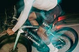 Image of cyclist on cycle, blurred by the light