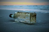 An empty liquor bottle on the ground.