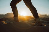 Person walking through the desert at sunrise, symbolizing the journey toward completing tasks and achieving personal goals.