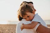 boy hugging woman during daytime