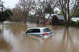 A car sinking underwater during a flood.