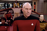 An image from Star Trek, showing Captain Piccard and others wearing “universal translators”.