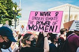 Protesters holding a sign saying “Never underestimate the power of women”