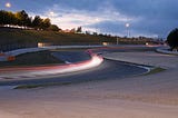 Blurred race car on track during the evening.