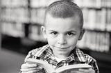 Photo of a small boy, reading.