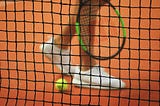 Tennis player with racket, ball and net