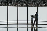A father and child standing at the window in an airport.