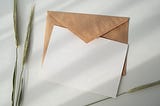 A brown envelope underneath a white blank card