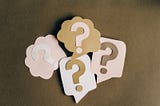 Four construction paper question mark bubbles