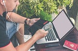 A guy with an open laptop counts the money in his wallet