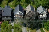 An overhead view of four moderately appointed houses in a beautifully treed neighbourhood.