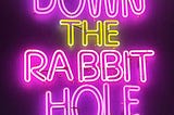 A pink and yellow neon sign that says down the rabbit hole