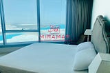 Image of bedroom with outside view and Miramar Logo