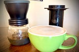 coffee grinder, aeropress, and a latte