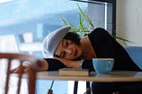 woman in black long sleeve shirt lying on white wooden table