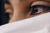 A sad-looking woman with tears in her eyes, her eyes are averted from the camera