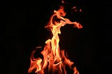 Crisp photo of bright orange and yellow flames centered against a solid black background.