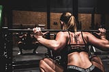 Photograph of a female weightlifter in workout attire performing a squat.