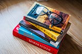 a stack of books with glasses on top