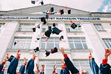 Graduates throw caps into the air