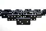 Black and white Dominos facing the camera in a pyramid formation