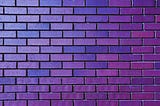 A section of brick wall in close-up in various hues of purple.
