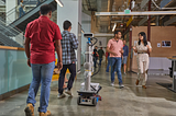 A robot navigates between 4 people walking in an office space