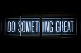 Neon lights reading “Do something great”