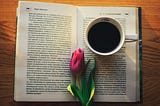 a picture of a paper book with a tulip and a cup of coffee