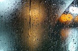 Rain on glass, lights beyond