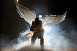 Dark silhouette angel with white wings on a cloud with a fishing pole.