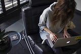 A woman writing on her laptop computer