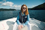 Girl with red hair, sitting in a boat