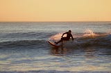 A man surfing during a sunset.