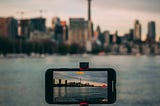 iphone taking video of large city across a body of water