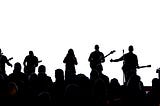 Silhouette of a group of six musicians performing to an audience