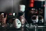 An image of a face showing panic, drawn on an egg, on a kitchen table