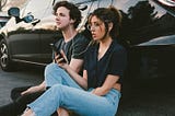 A couple sitting next to each other and listening to music from their collaborative playlist