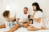 Image of a family sitting on their bed