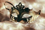 A masquerade ball mask kept on bright lights.