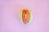 Photo of a honeymelon with grapefruit slices inside it to depict a vulva