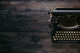 Typewriter on dark wood desk.