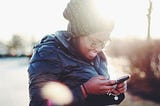 Girl smiling at phone in the sunlight