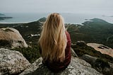 Girl sitting on a mountain overlooking a beautiful view.