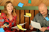 Sophia Prater and Joe Natoli laughing together as illustrated blue, pink, yellow, and green sticky notes fall like leaves around them.