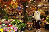 Woman in a market bursting with colorful goods