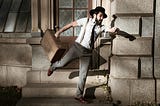 Bearded man rushing with cap on head and box in hand