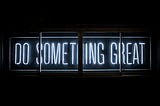 An image of neon lights saying “Do something great”